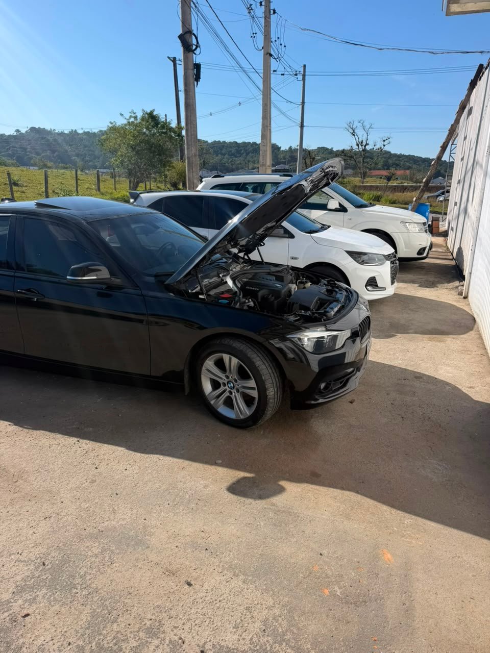 Carros aguardando atendimento na PROAUTO Multimarcas, com capô aberto para diagnóstico