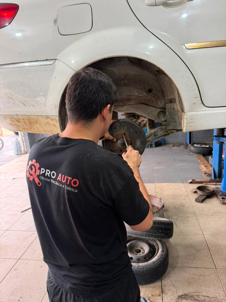 Mecânico da PROAUTO Multimarcas fazendo revisão de freio e cubo de roda